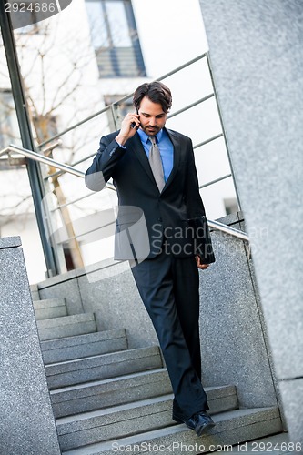 Image of Businessman listening to a call on his mobile