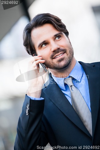 Image of Businessman listening to a call on his mobile