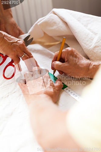 Image of Hand Cutting Cloth with Scissors