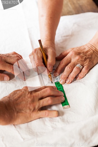 Image of Hand Cutting Cloth with Scissors