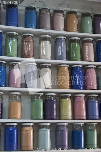 Image of Shelving with glass jars of colorful pigments