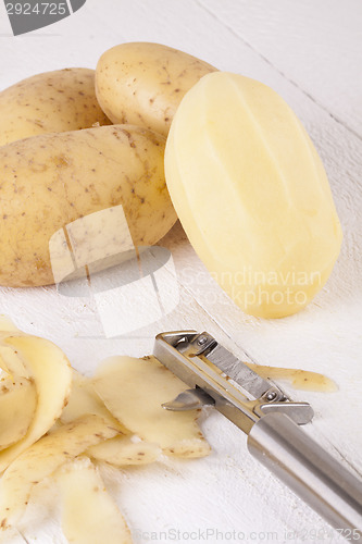 Image of Potatoes with Peeler and Peeled Skin