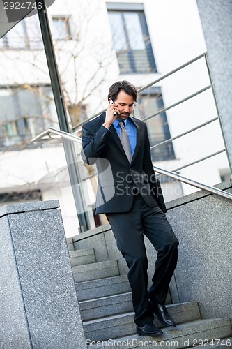 Image of Businessman listening to a call on his mobile