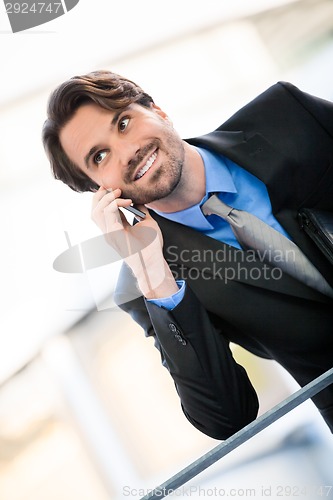 Image of Businessman listening to a call on his mobile