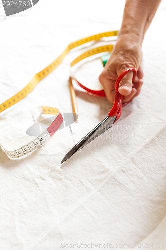 Image of Hand Cutting Cloth with Scissors