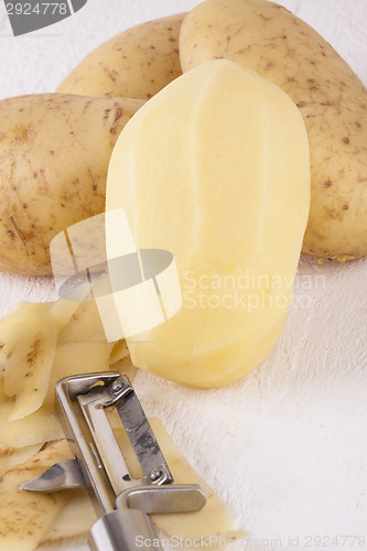 Image of Potatoes with Peeler and Peeled Skin