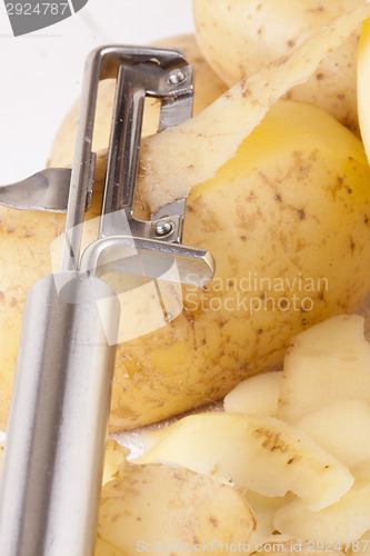 Image of Potatoes with Peeler and Peeled Skin