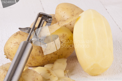 Image of Potatoes with Peeler and Peeled Skin