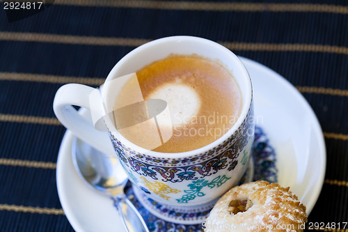 Image of Cup of freshly brewed tea and a cookie