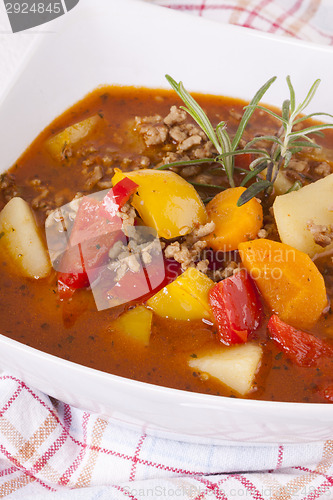 Image of Hearty Stew in Bowl and Spoon on Plaid Dish Towel