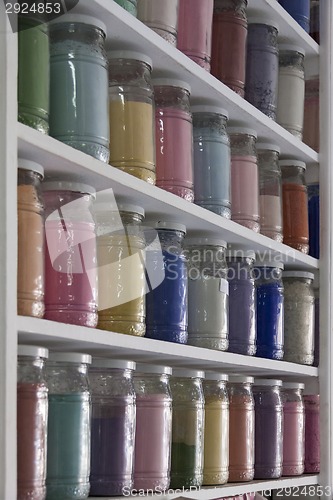 Image of Shelving with glass jars of colorful pigments