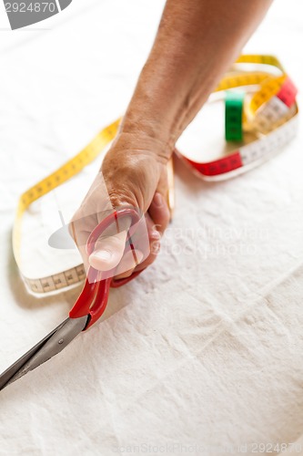 Image of Hand Cutting Cloth with Scissors