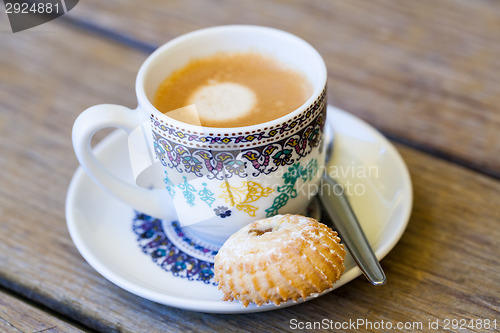 Image of Cup of freshly brewed tea and a cookie