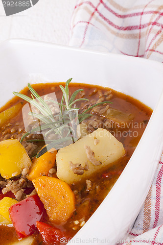 Image of Hearty Stew in Bowl and Spoon on Plaid Dish Towel