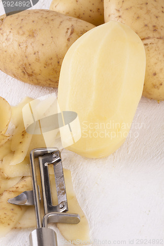 Image of Potatoes with Peeler and Peeled Skin