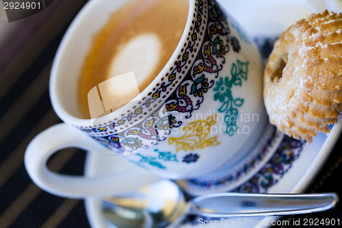 Image of Cup of freshly brewed tea and a cookie