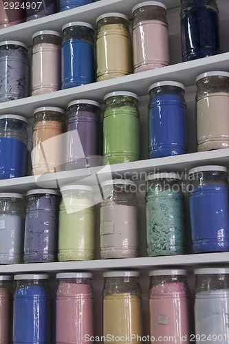 Image of Shelving with glass jars of colorful pigments