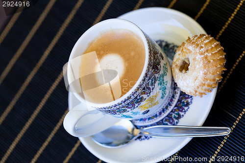 Image of Cup of freshly brewed tea and a cookie