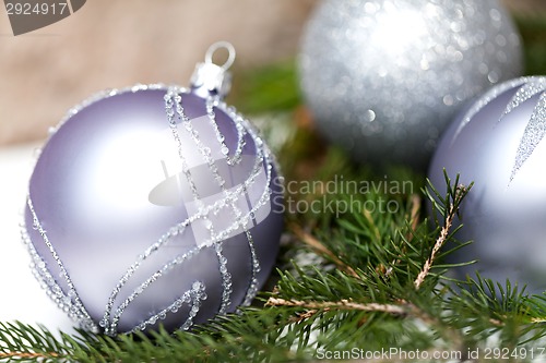 Image of Silver Christmas ornaments in leaves