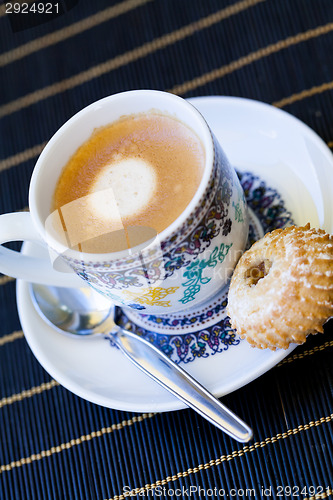 Image of Cup of freshly brewed tea and a cookie