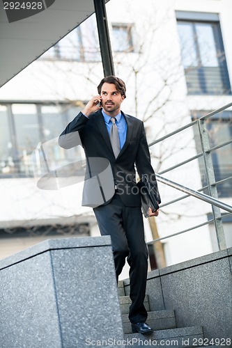 Image of Businessman listening to a call on his mobile