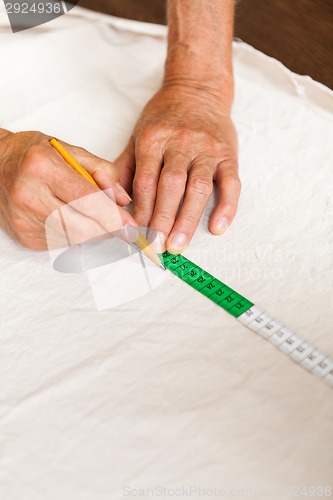 Image of Hand Cutting Cloth with Scissors