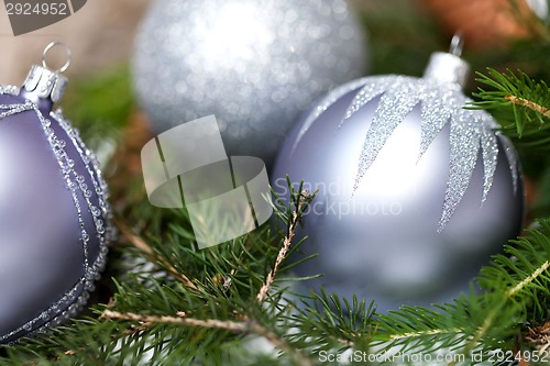 Image of Silver Christmas ornaments in leaves