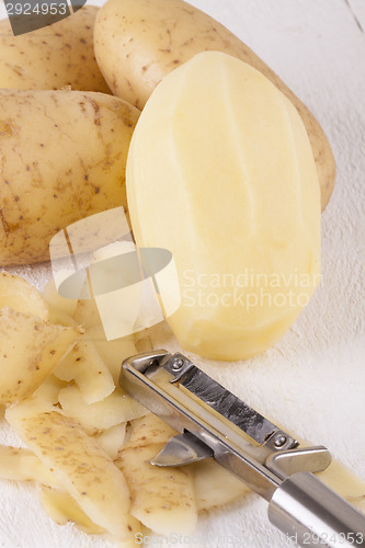 Image of Potatoes with Peeler and Peeled Skin