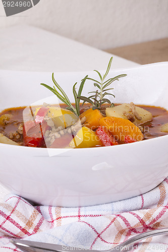 Image of Hearty Stew in Bowl and Spoon on Plaid Dish Towel