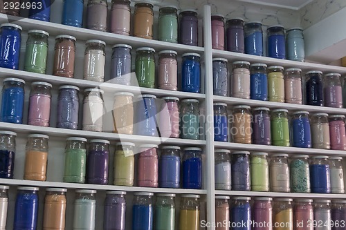 Image of Shelving with glass jars of colorful pigments