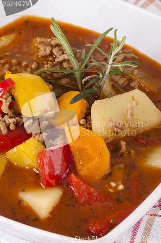 Image of Hearty Stew in Bowl and Spoon on Plaid Dish Towel