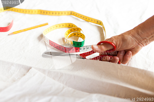 Image of Hand Cutting Cloth with Scissors