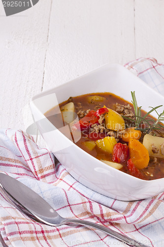 Image of Hearty Stew in Bowl and Spoon on Plaid Dish Towel