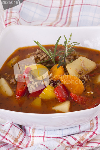 Image of Hearty Stew in Bowl and Spoon on Plaid Dish Towel