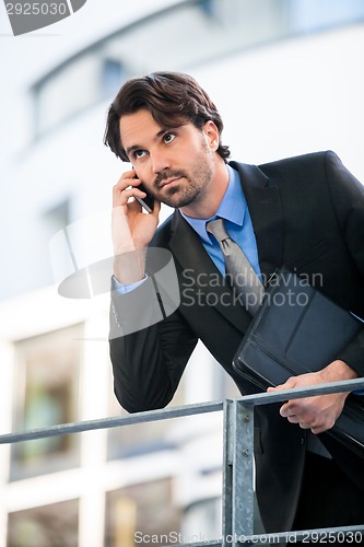 Image of Businessman listening to a call on his mobile