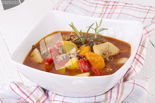 Image of Hearty Stew in Bowl and Spoon on Plaid Dish Towel