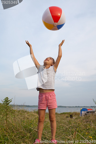 Image of Little girl playing with a ball outdoors