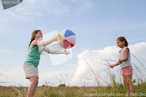Image of Young girls playing with a ball outdoors