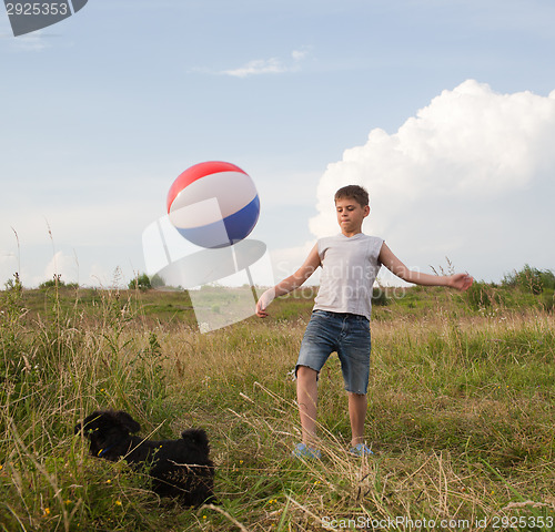 Image of Young boy playing with a ball outdoors