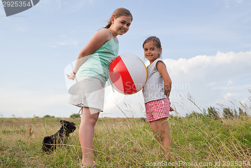 Image of Young girls playing with a ball outdoors