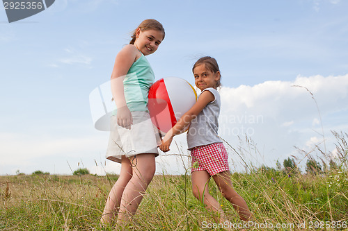 Image of Young girls playing with a ball outdoors