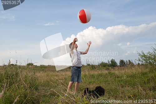 Image of Young boy playing with a ball outdoors