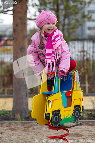 Image of Little girl on the carousel in the autumn