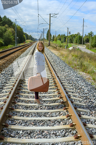 Image of Young girl with suitcase at railways
