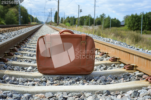 Image of Vintage brown suitcase on the railway