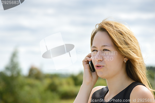 Image of Beautiful caucasian girl talking to smart phone