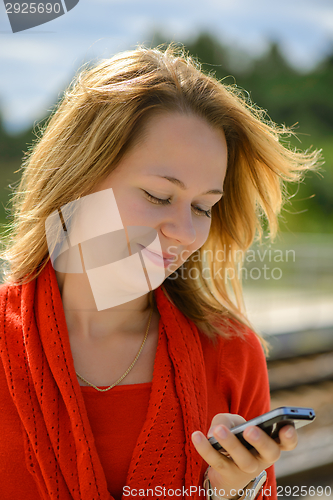 Image of Happy young caucasian girl with smart phone