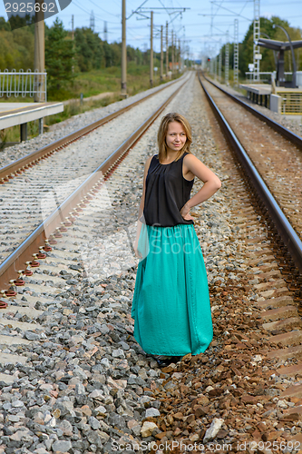 Image of Standing girl between two railway path