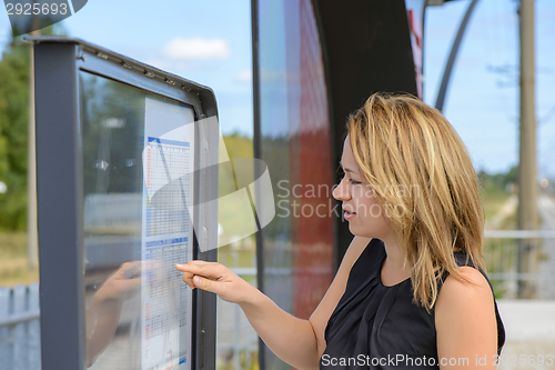 Image of Woman looking a timetable in a station