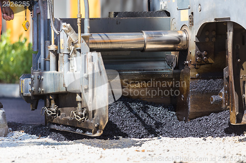 Image of Asphalt surfacing manual labor.